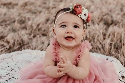 Elle Shaddai Joy Pruitt — portrait at ten months in pink dress with flower headband